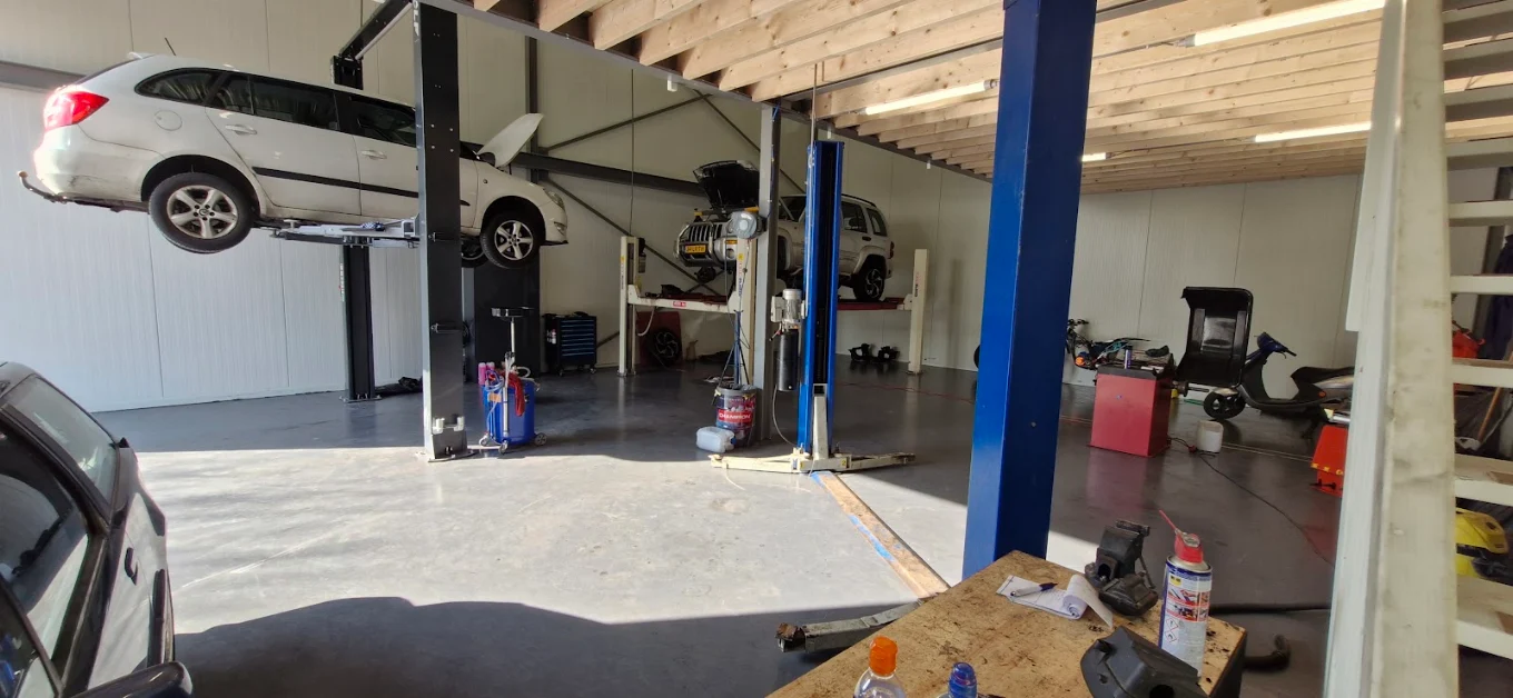 De werkplaats van Arnold's Garage met een auto op de hefbrug